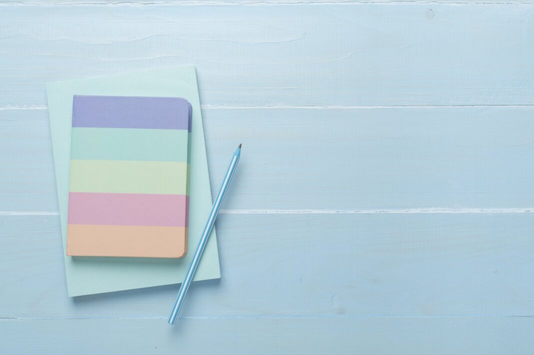 Notebooks with stationery on wooden background, top view